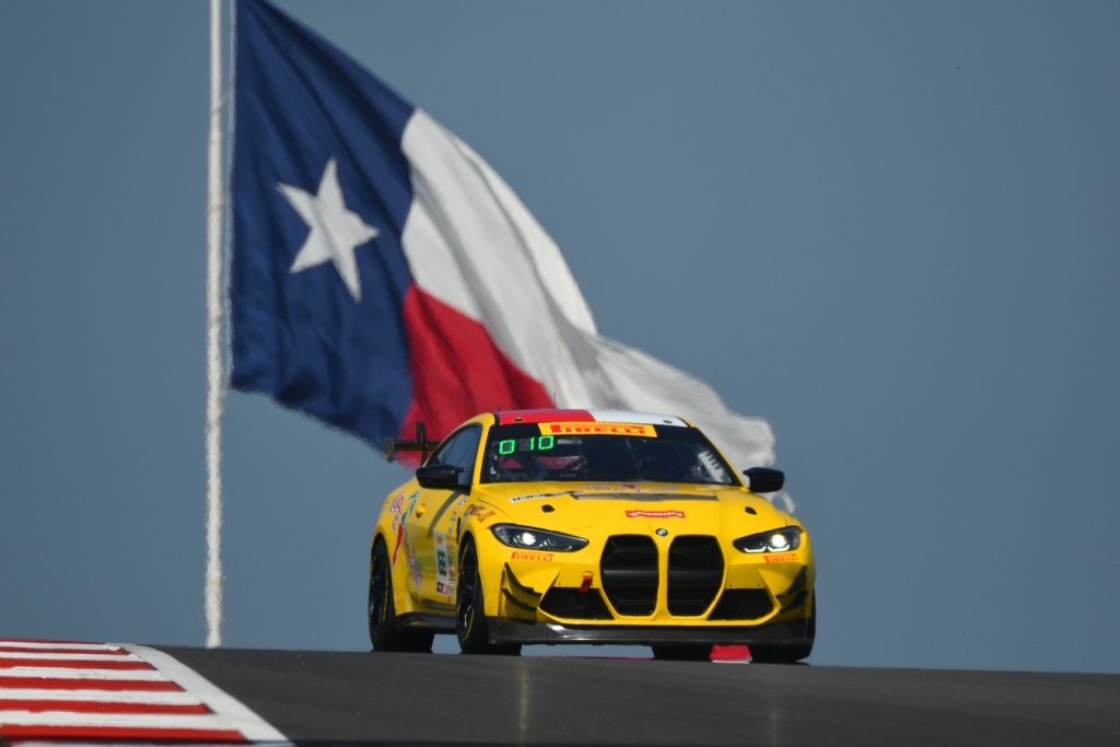 BMW M4 GT4 at Circuit of the Americas under the Texas flag